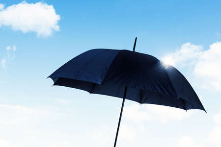 Insurance concept. Close up of black umbrella with blue sky background. Shot at outdoorsの写真素材