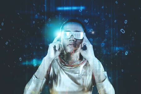 Picture of female robot wearing futuristic glasses while standing in the cyberspace with code binary backgroundの写真素材
