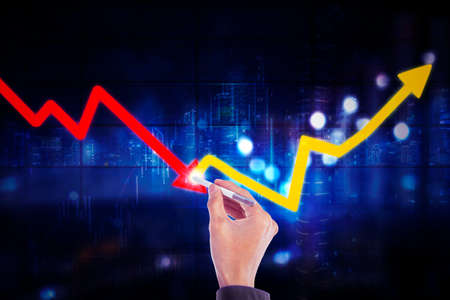 Close up of businessman hand using a stylus pen while changing declining arrow to upward arrow with night city backgroundの写真素材