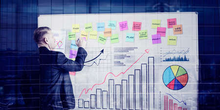 Double exposure of businessman giving presentation with financial graph while standing with modern...