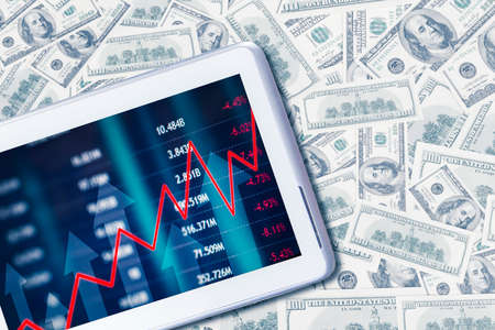 Double exposure of digital tablet screen with growth currency exchange rate chart above stacks of...
