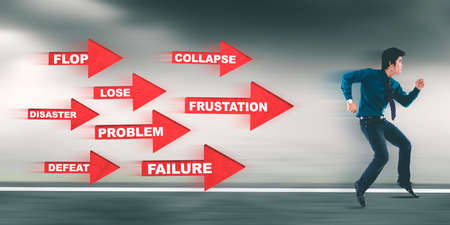 Young businessman escaping from red arrows with his problems while running on the road with fast motion backgroundの写真素材