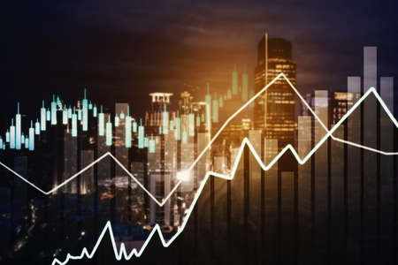 Double exposure of growth graph and candlesticks with glowing city backgroundの写真素材
