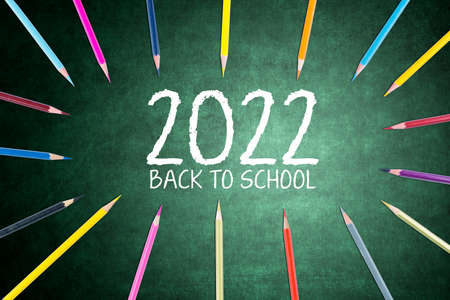 Close up of colored pencils shaping a circle around number 2022 and back to school text on the...