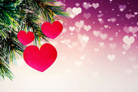 Close up of heart ornaments decorating pine tree with shining hearts symbol backgroundの写真素材