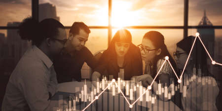 Double exposure of diversity business people analyzing candlesticks chart with sunlight backgroundの写真素材