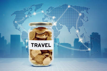 Image of travel word on the glass jar full of money with airplane routes on world map backgroundの写真素材