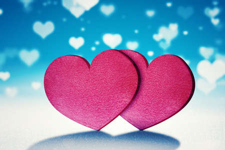 Image of two red gift boxes on the table with blurred white heart symbol backgroundsの写真素材