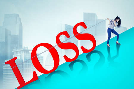 Businesswoman pulling loss word while climbing on the mountain with cityscape background