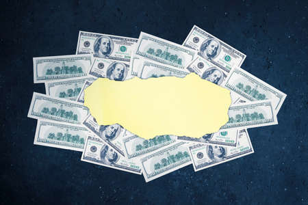 Image of empty torn paper with heaped dollar banknotes over blackboard backgroundの写真素材