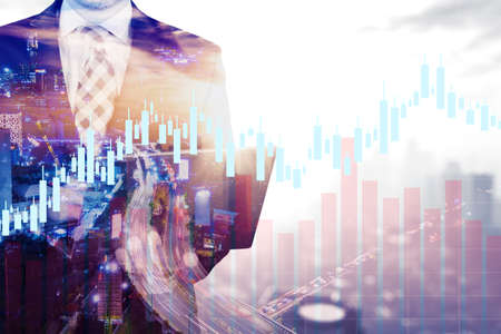 Double exposure of male manager hands using a laptop while standing with candlestick chart and...