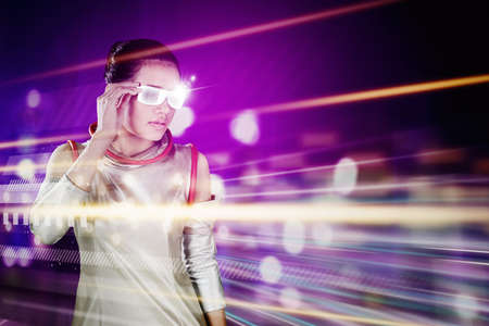 Young woman wearing futuristic glasses while standing in the metaverse with fast motion background