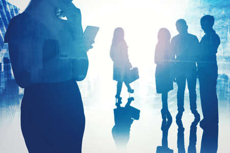 Silhouette of crowded business people doing activity while standing in the office with cityscape...