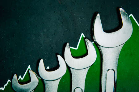 Close up of set of wrenches shaping growth chart with blackboard backgroundの写真素材