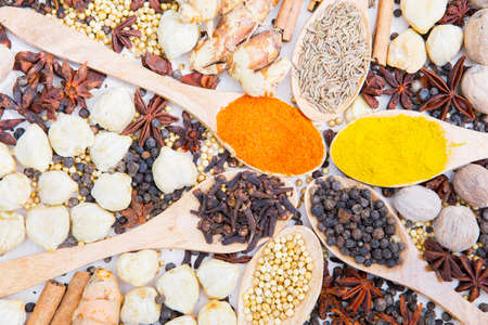 Top down view of spices and herbs with wooden spoon on the table