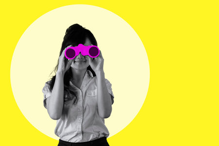 smiling young business woman looking through binoculars on yellow background collage in magazine style. Contemporary art. Modern designの写真素材