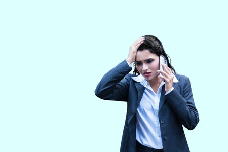 Stressed Indian woman cover her face with hand and feel upset while talk on mobile phoneの写真素材