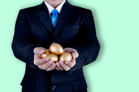 Businessman holding golden eggs - investment investor conceptの写真素材