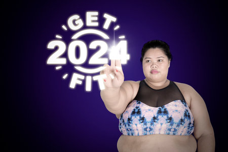 New year health resolution concept - Overweight woman wearing sportswear while touching a virtual...
