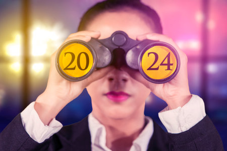 Female entrepreneur using binoculars with the 2024 new year numbers on itの写真素材