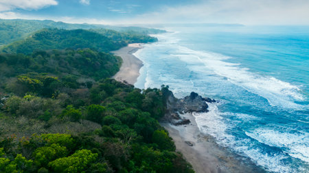Aerial view of Pangandaran beach, a tourist attraction on Indonesia tropical island. Beautiful nature in bali, with mountains and peaceful waters - perfect for an adventurous Indonesian holidayの写真素材