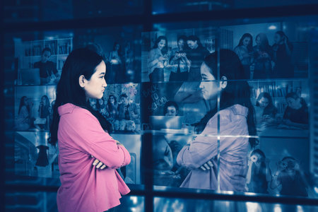 Sad introvert lonely female teenager looking at windowの写真素材