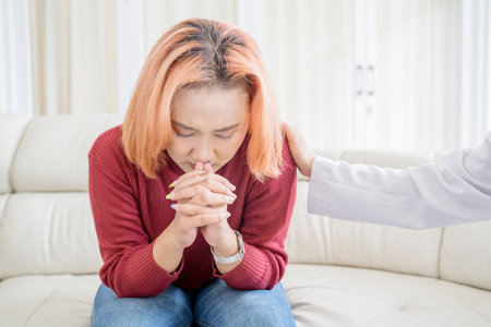 Psychotherapist comforting Asian young woman a mental health clinic