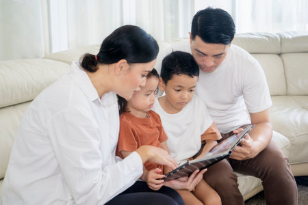 Happy Asian family looking at a photo album at home