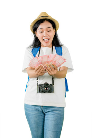 Excited Female Traveler Holding a Large Amount of Moneyの写真素材