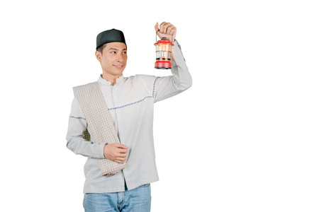 Muslim Man Holding a Lantern in Traditional Islamic Attire, Symbolizing Ramadan and Spiritual Lightの写真素材
