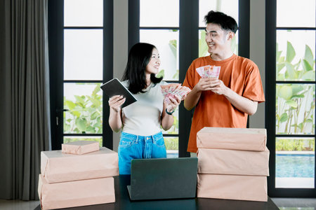 Successful Young Entrepreneurs Managing Online Business and Counting Profitsの写真素材