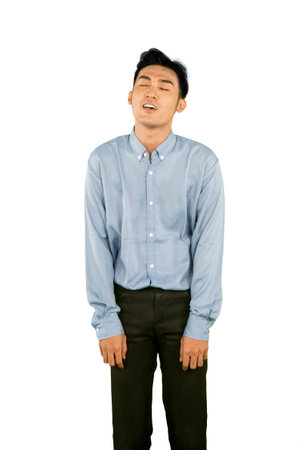 Tired Young Man in Formal Attire Expressing Exhaustion on White Backgroundの写真素材