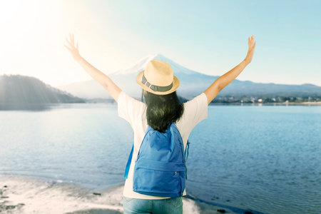 Happy Female Traveler Enjoying Scenic View of Mount Fuji and Lakeの写真素材