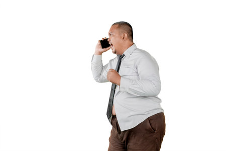 Angry Overweight Businessman Yelling on Phone in Formal Attire on White Backgroundの写真素材