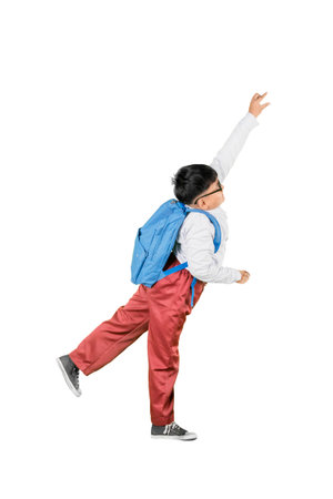 Playful Schoolboy Reaching Up with Backpack Isolated on White Backgroundの写真素材