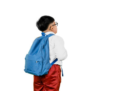 Rear View of Indonesian Schoolboy Wearing Backpack and Looking Up Isolated on White Background