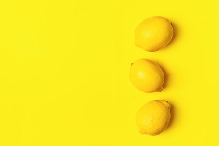 Fresh juicy lemon on a bright yellow background. Concept minimalism. Horizontal frame. Copy space. Flat Layout Top Viewの写真素材