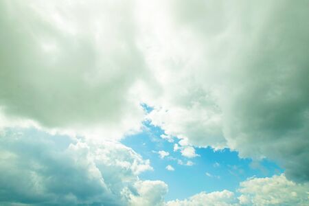 White fluffy thick clouds against the blue sky. Natural background wallpaper. The concept of clean...