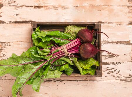 Fresh natural beets crate rustic wooden background. Autumn summer harvest concept. Top view flat layout. Natural style.の写真素材