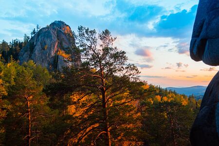 Evening mountain landscape. Mountains rocks trees against the setting sun. Krasnoyarsk National Park Pillars.の写真素材