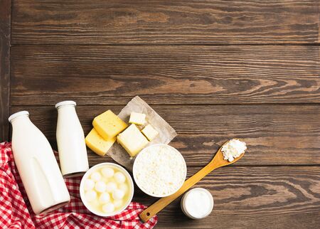 Dairy and sour milk products on a wooden dark rustic background. Milk, kefir, yogurt, butter, cheese assortment. Flat layout top view. Copy space. Horizontal frameの写真素材