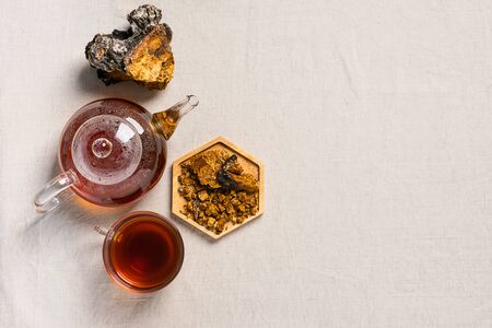 Healing tea from chaga birch mushrooms in a glass teapot and glass. Organic drink antioxidant gray natural background.の写真素材