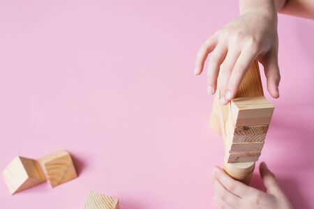 The child collects the designer builds a house of wooden cubes. Toys from environmental natural...