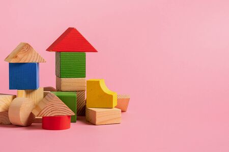 Childrens wooden toys on a pink background concept zero west. Small houses the designer from...