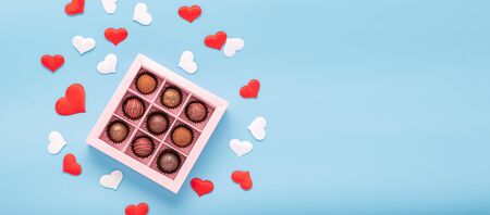 Chocolate truffle candies in a box on a blue background with valentines. Valentines day concept...