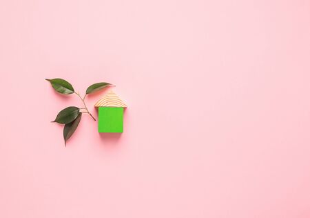 House made of wooden cubes on a pink background. The concept of building houses from environmentally friendly materials.の写真素材