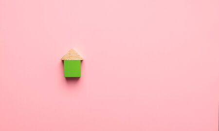 House made of wooden cubes on a pink background. The concept of building houses from environmentally friendly materials.の写真素材