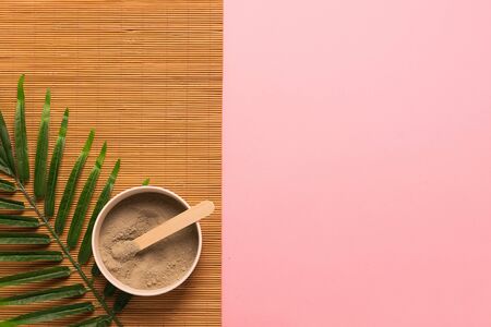 Natural skin care products at home. Gray clay in a jar on a pink background with green leaves. Horizontal frameの写真素材