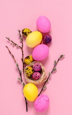 Happy easter concept. Colored eggs on a pink background. Vertical frame flat layout.の写真素材