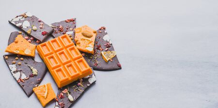 Chocolate bright orange fruit whole tile decorated with slices fruit nuts and slices on a gray...